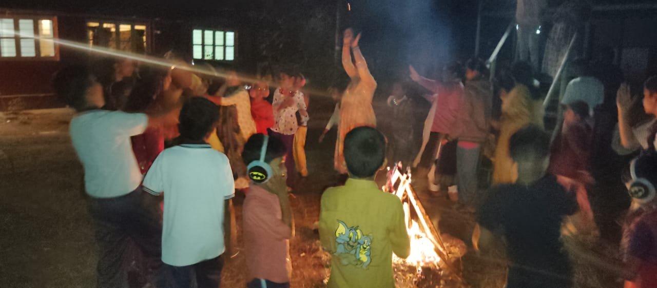 Guests enjoying a lively campfire night and relaxing after fun games and activities.